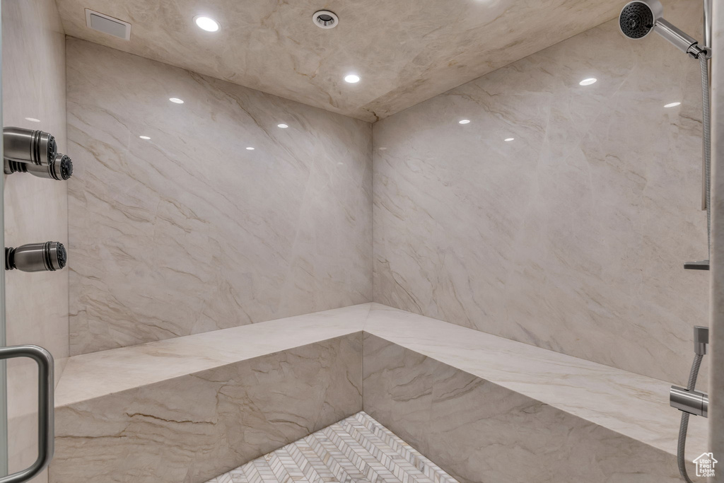 Full bathroom featuring a marble finish shower and recessed lighting