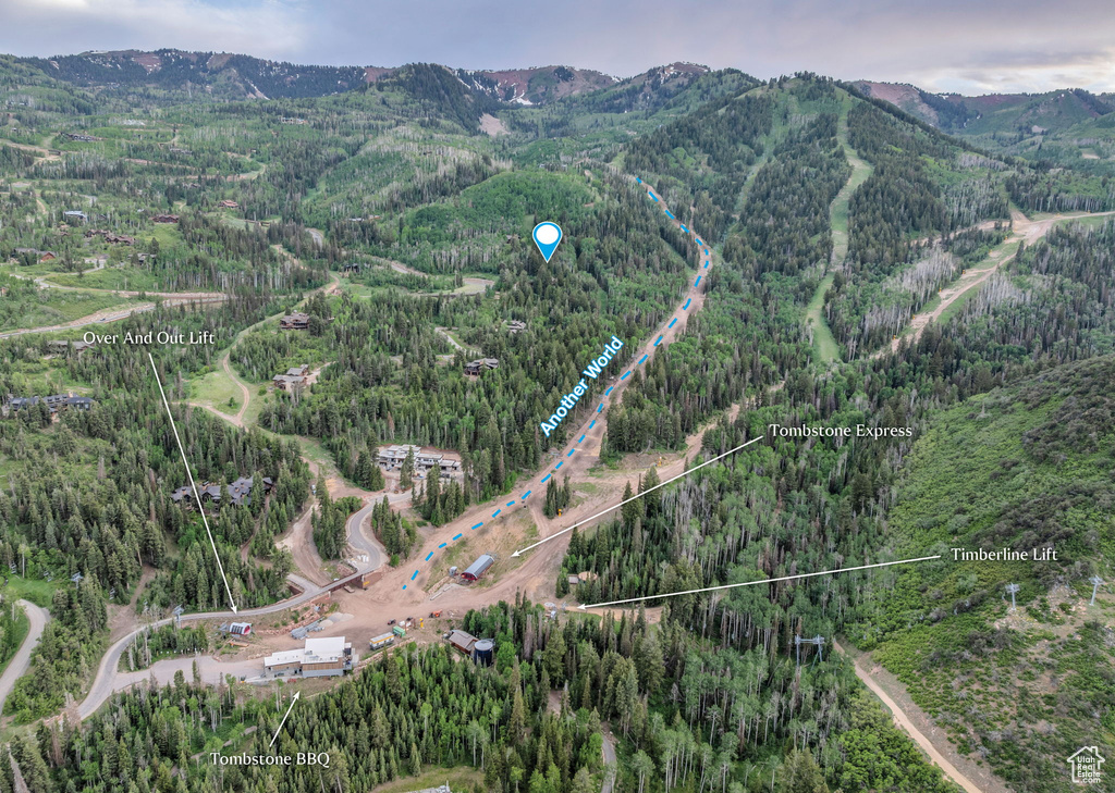 Aerial overview of property's location with a mountain backdrop and property boundaries highlighted
