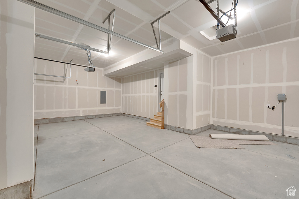 Garage featuring a garage door opener and baseboards