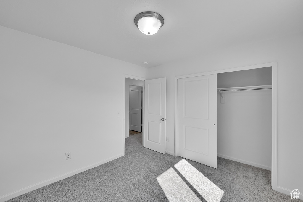Unfurnished bedroom with carpet flooring, baseboards, and a closet