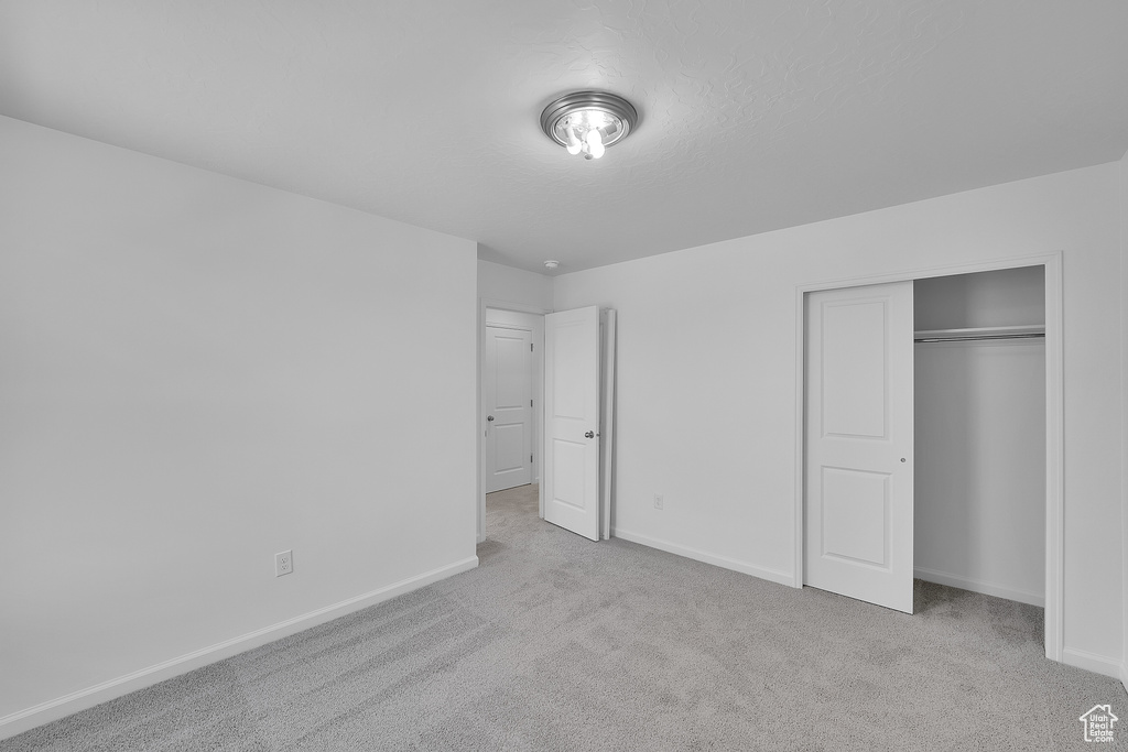 Unfurnished bedroom with carpet, baseboards, and a closet