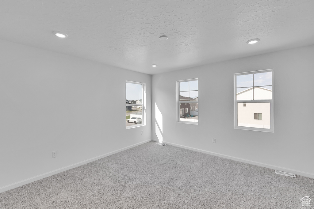 Carpeted empty room with baseboards, recessed lighting, and a textured ceiling