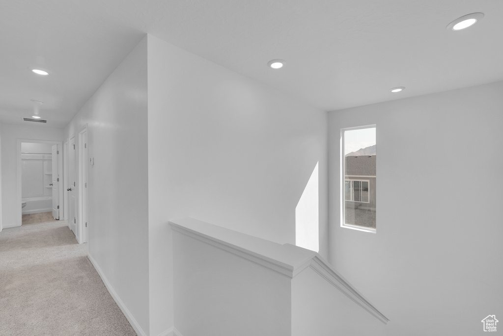 Hallway with carpet floors, recessed lighting, baseboards, and an upstairs landing