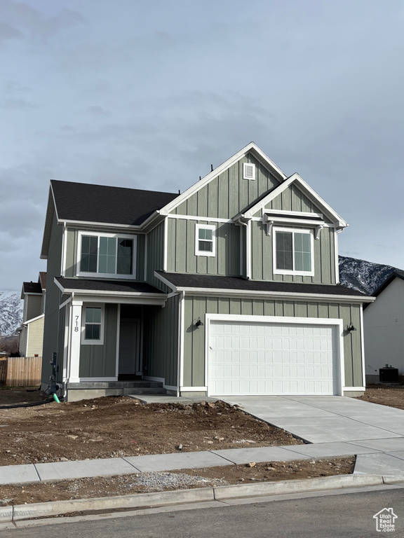 View of front of home with a garage and central AC unit