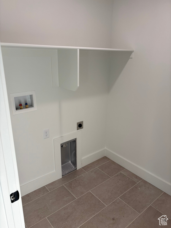Washroom with hookup for a washing machine, dark tile patterned floors, and hookup for an electric dryer