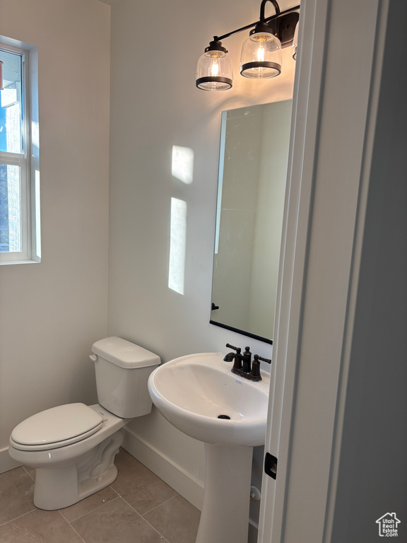 Bathroom featuring toilet, tile patterned flooring, and sink
