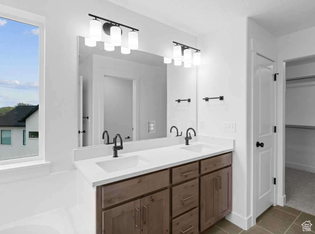 Bathroom featuring tile patterned flooring, a sink, and double vanity