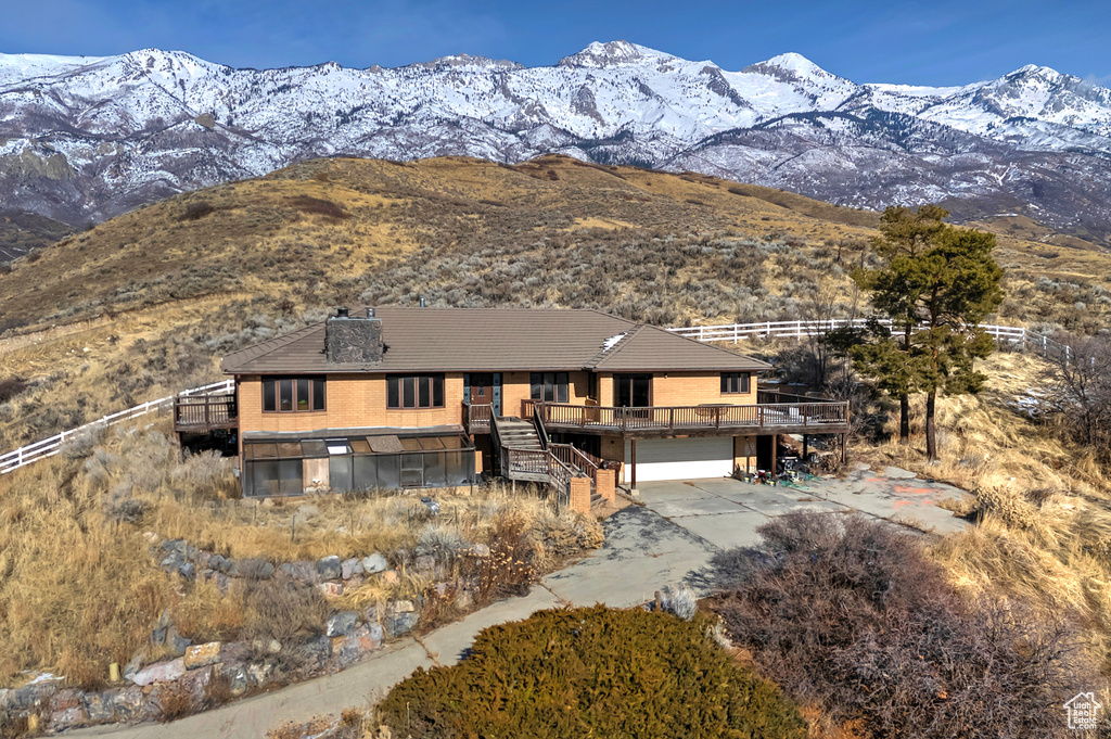 View of front of house with a deck with mountain view and a garage