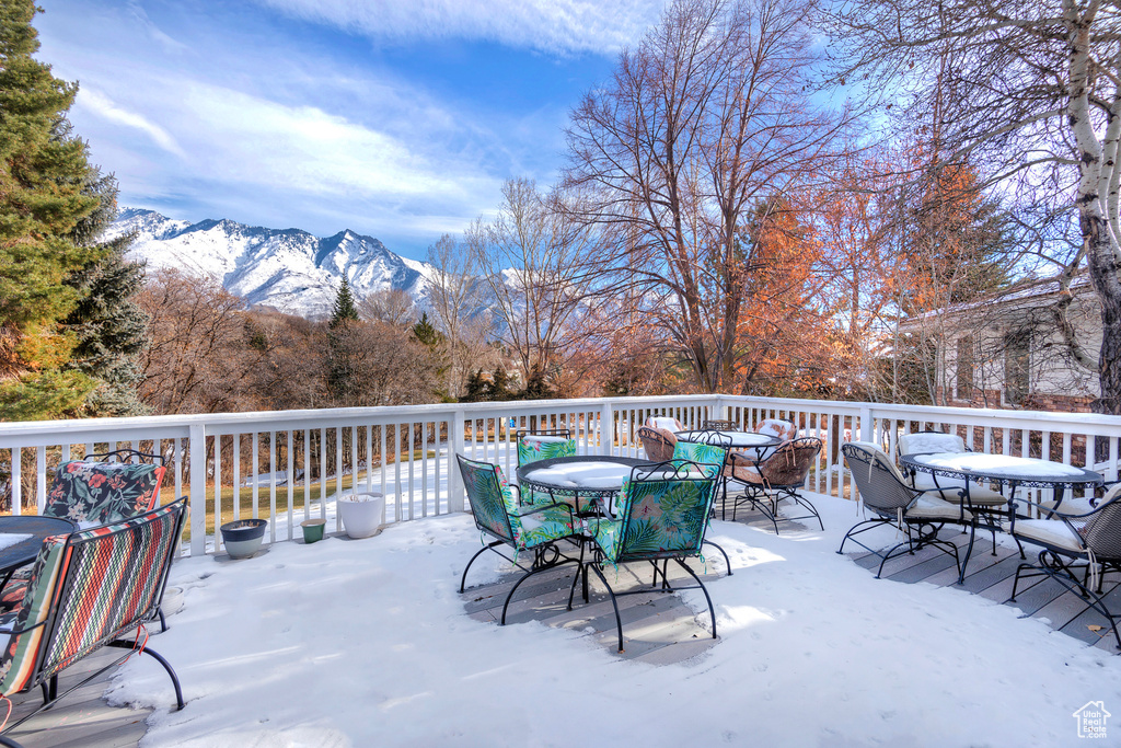 Snow covered deck with a mountain view