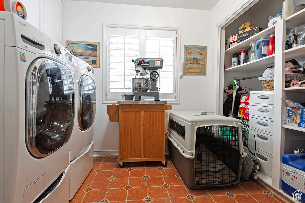 Laundry area featuring dark tile patterned floors and independent washer and dryer