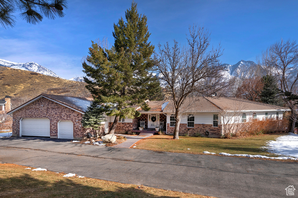 View of front of house with a mountain view, a front lawn, and a garage