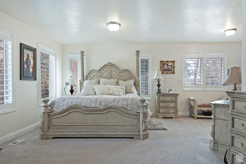 Bedroom featuring light carpet and a textured ceiling