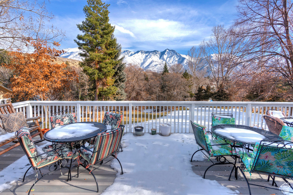 Snow covered deck with a mountain view