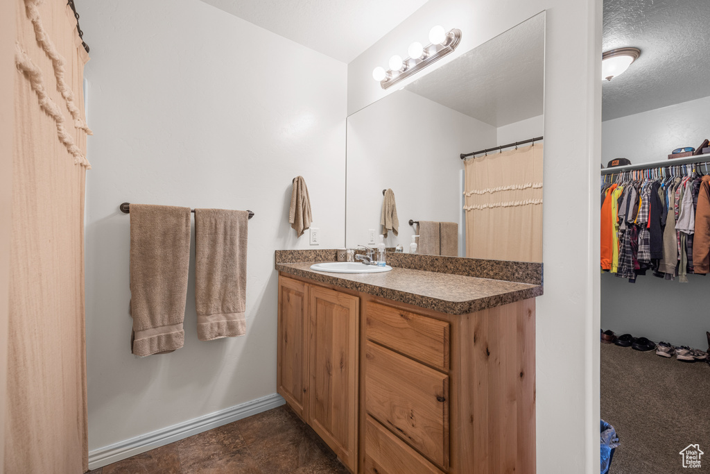 Bathroom featuring a textured ceiling and vanity