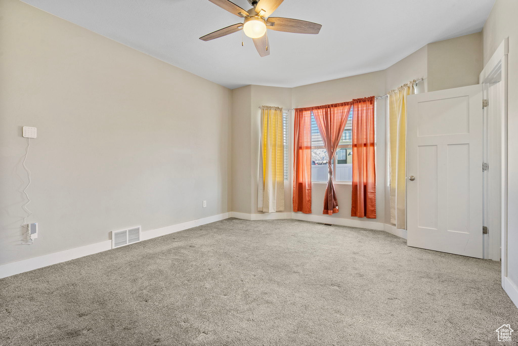 Unfurnished room featuring ceiling fan and carpet flooring