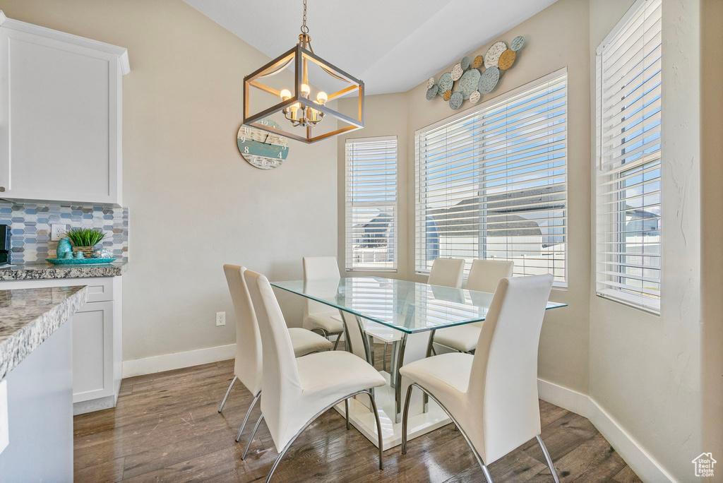 Dining room featuring a notable chandelier and dark wood-type flooring