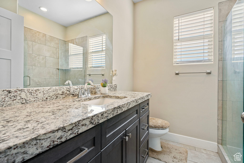 Bathroom featuring vanity, an enclosed shower, tile patterned floors, and toilet