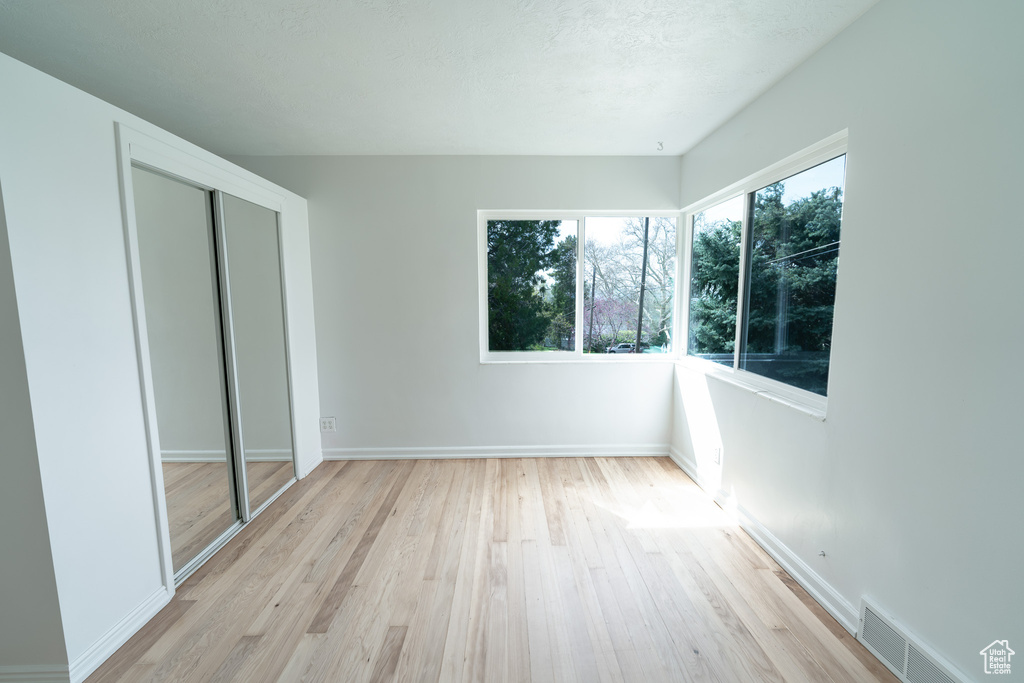 Unfurnished bedroom featuring light wood-type flooring and a closet