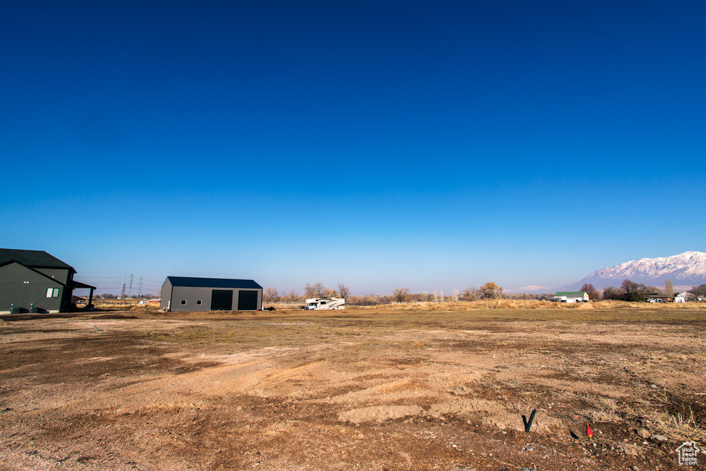 View of yard featuring an outdoor structure, a rural view, and a mountain view