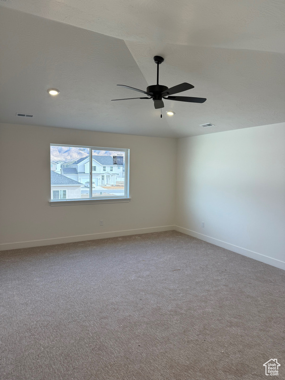Carpeted spare room featuring ceiling fan