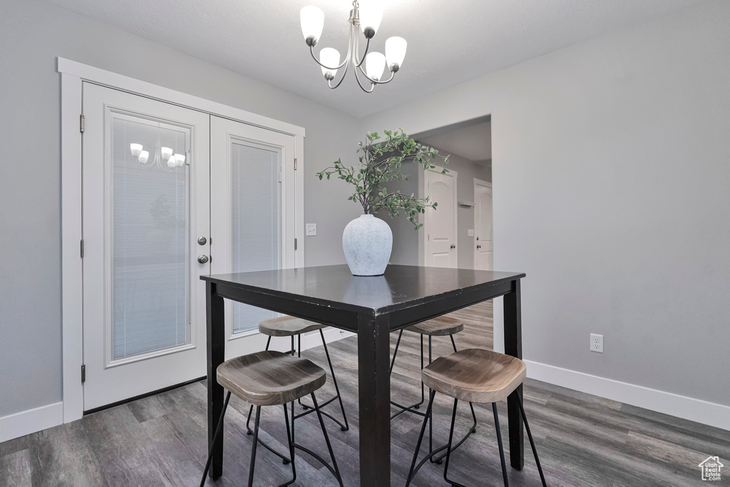Dining space featuring an inviting chandelier and dark hardwood / wood-style flooring