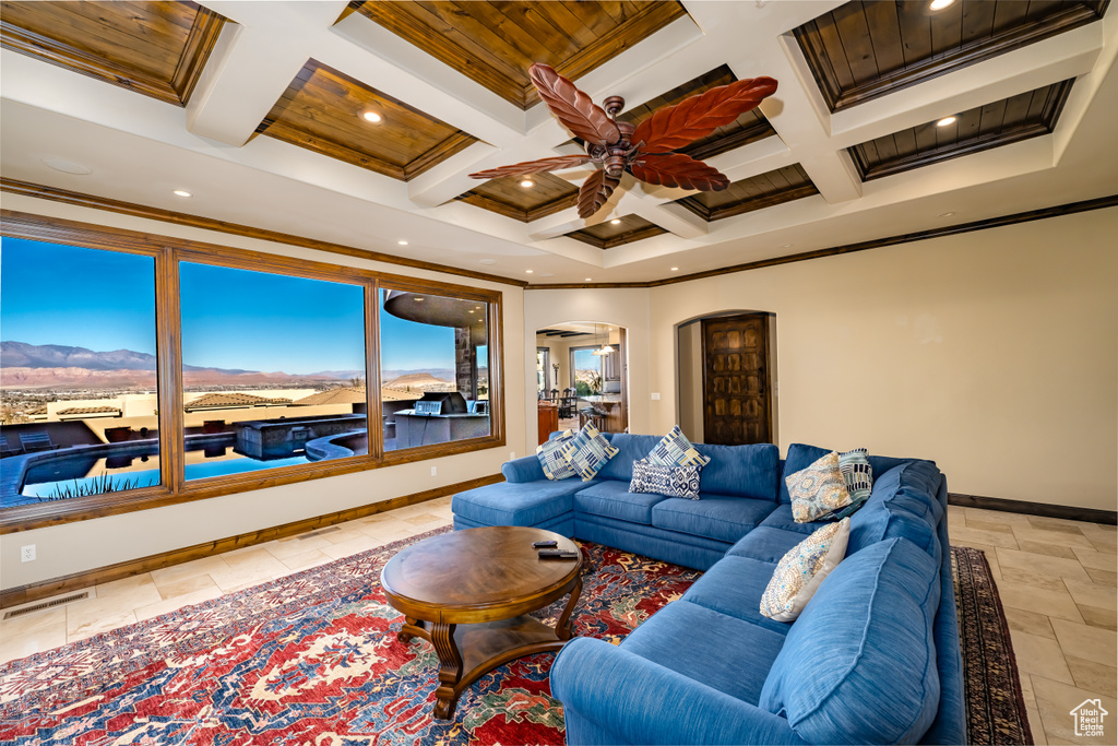 Living room with ceiling fan, ornamental molding, coffered ceiling, and beam ceiling