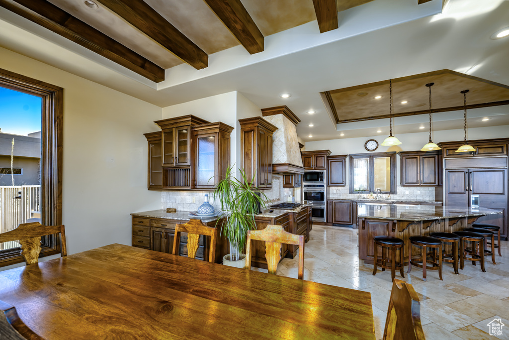 Dining area featuring sink, a wealth of natural light, and beam ceiling