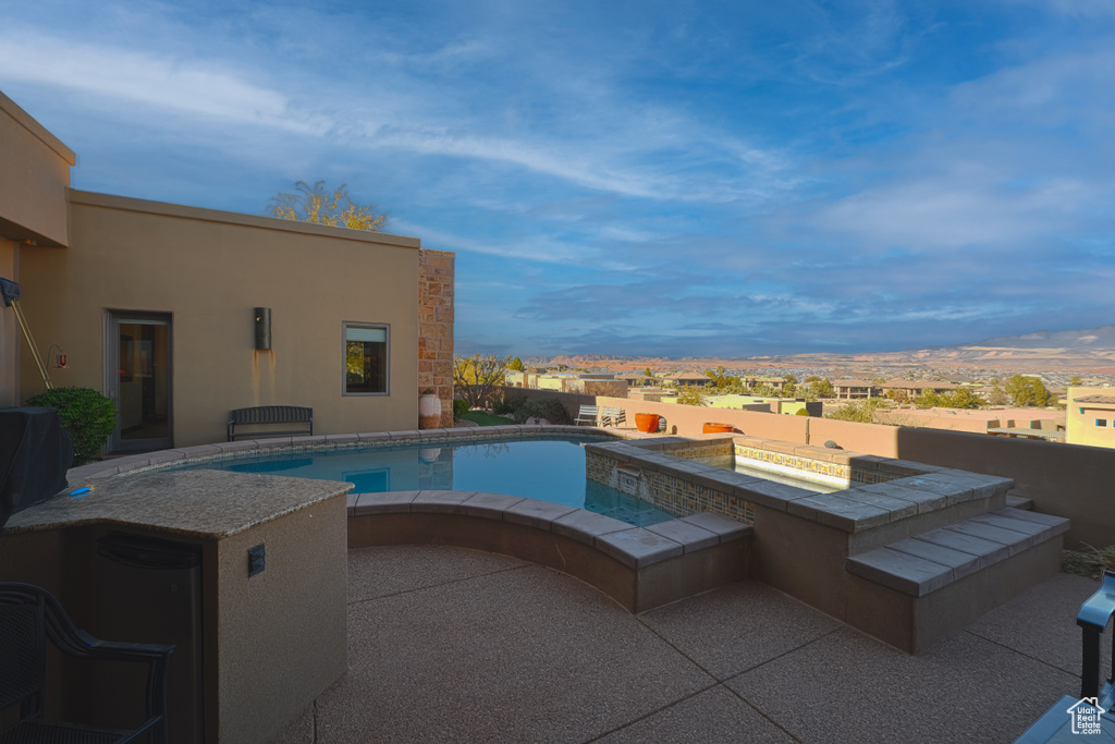 View of swimming pool with a jacuzzi and a patio