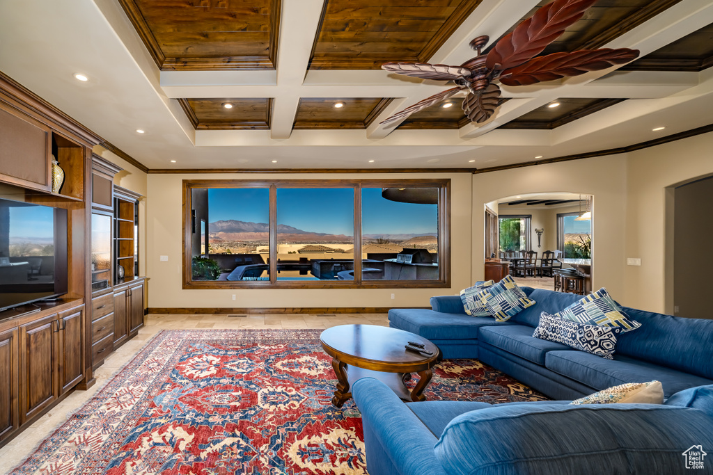 Living room featuring coffered ceiling, ceiling fan, crown molding, and beamed ceiling