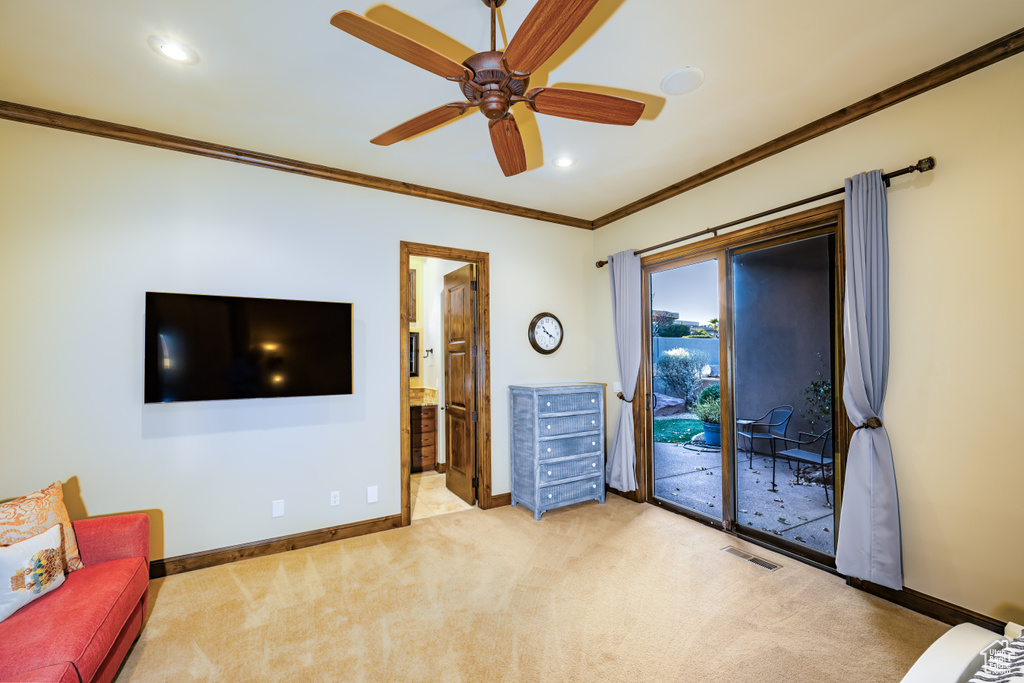 Unfurnished living room with ceiling fan, crown molding, and light colored carpet
