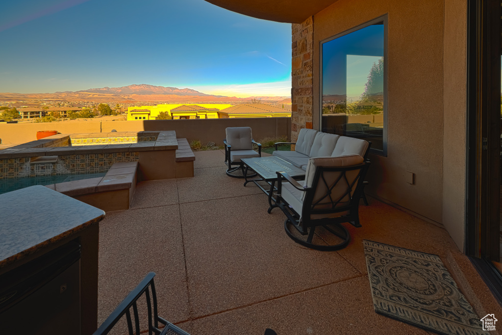 Patio terrace at dusk with outdoor lounge area and a mountain view