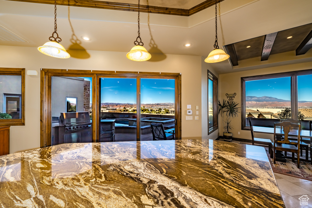 Kitchen with decorative light fixtures and stone countertops