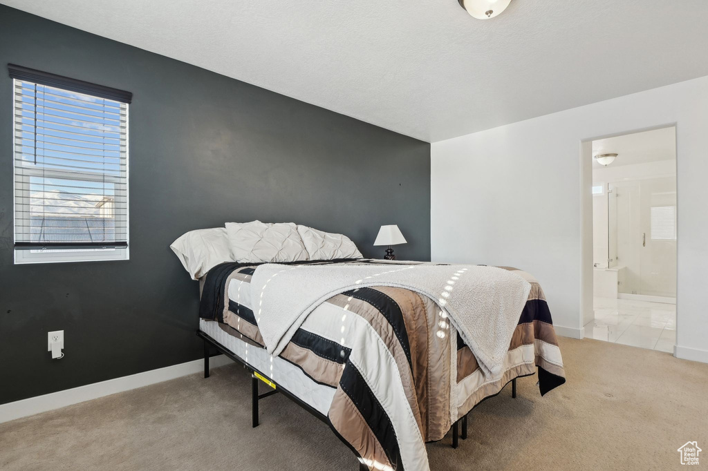 Bedroom featuring connected bathroom and light carpet