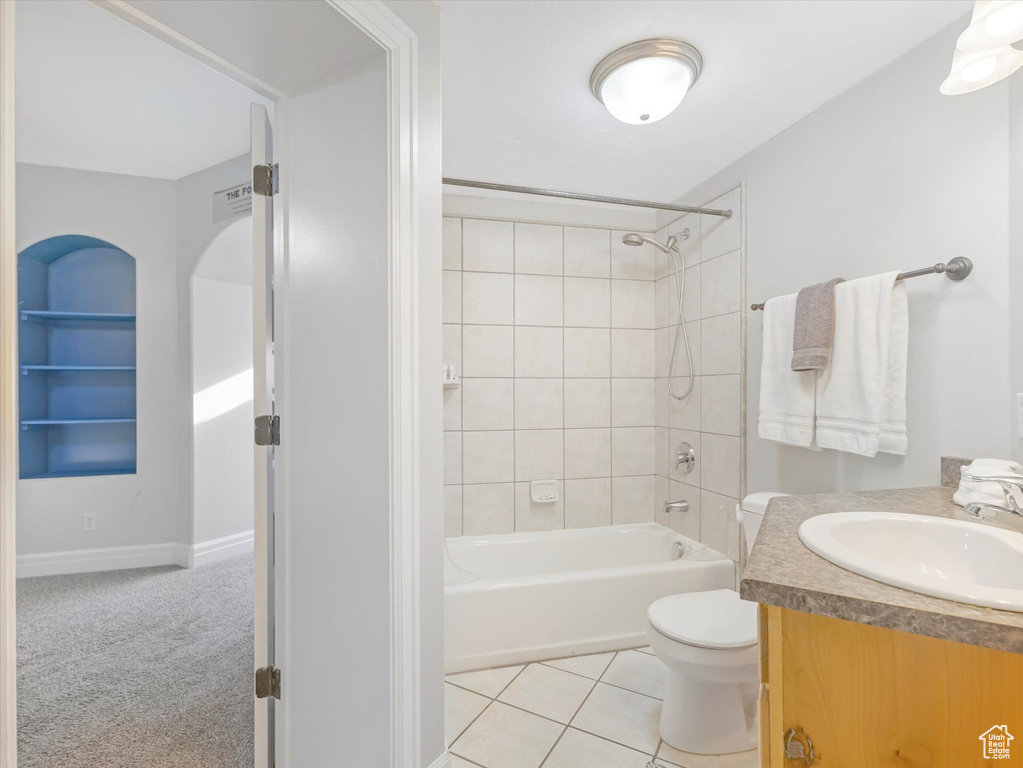 Full bathroom featuring toilet, tiled shower / bath, tile patterned floors, and vanity