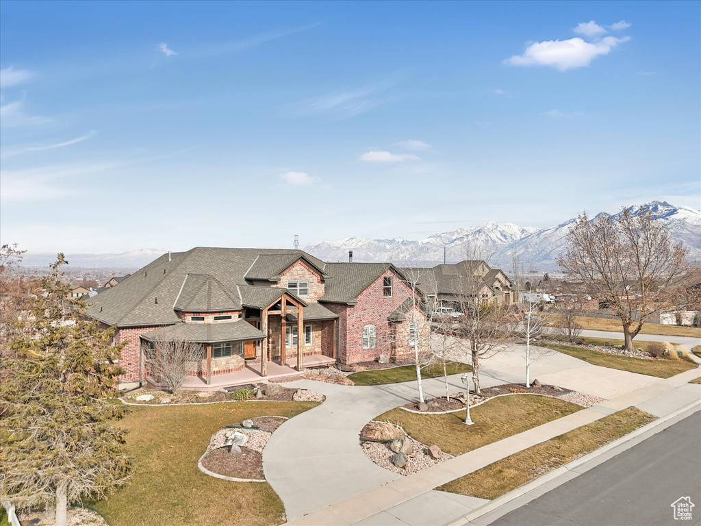 View of front facade featuring covered porch, a mountain view, and a front yard