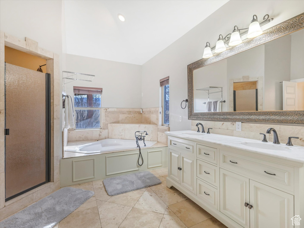 Bathroom featuring shower with separate bathtub, vanity, and tile patterned floors