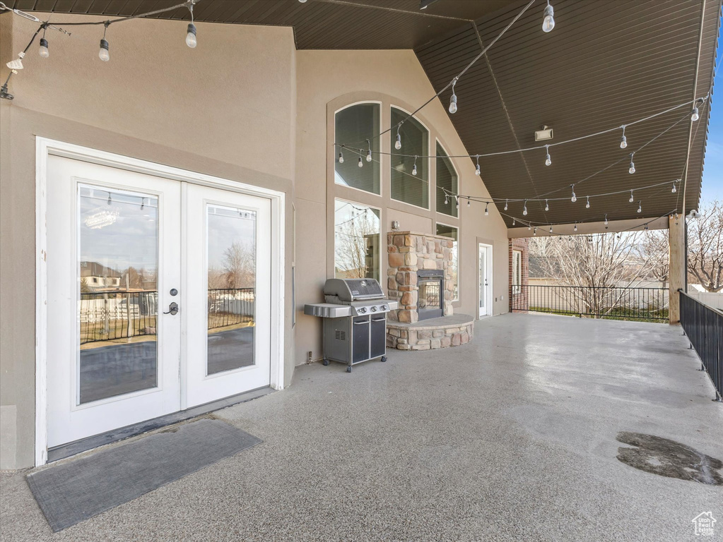 View of patio / terrace featuring area for grilling, french doors, and an outdoor stone fireplace
