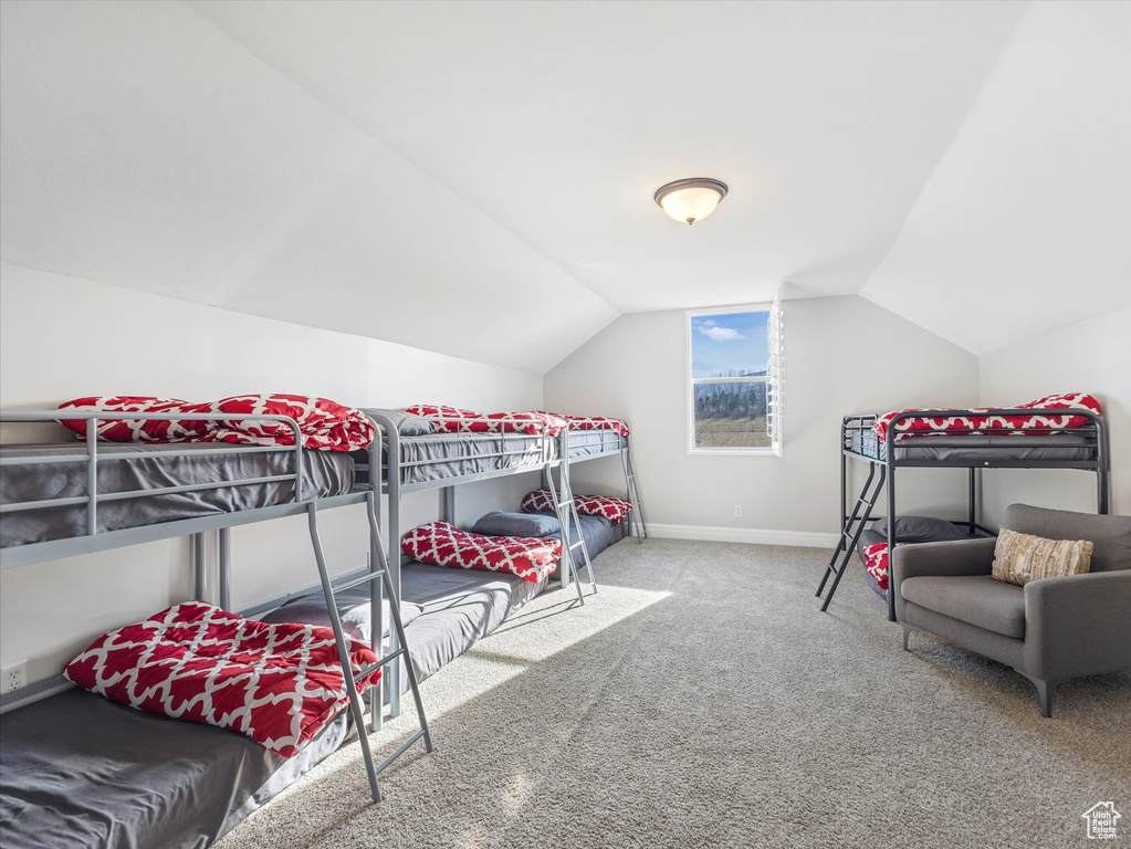 Carpeted bedroom featuring lofted ceiling