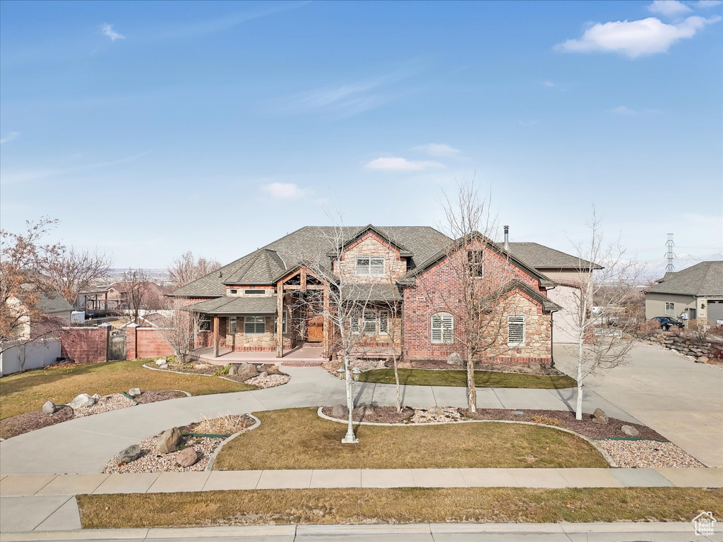 View of front of property featuring covered porch and a front lawn