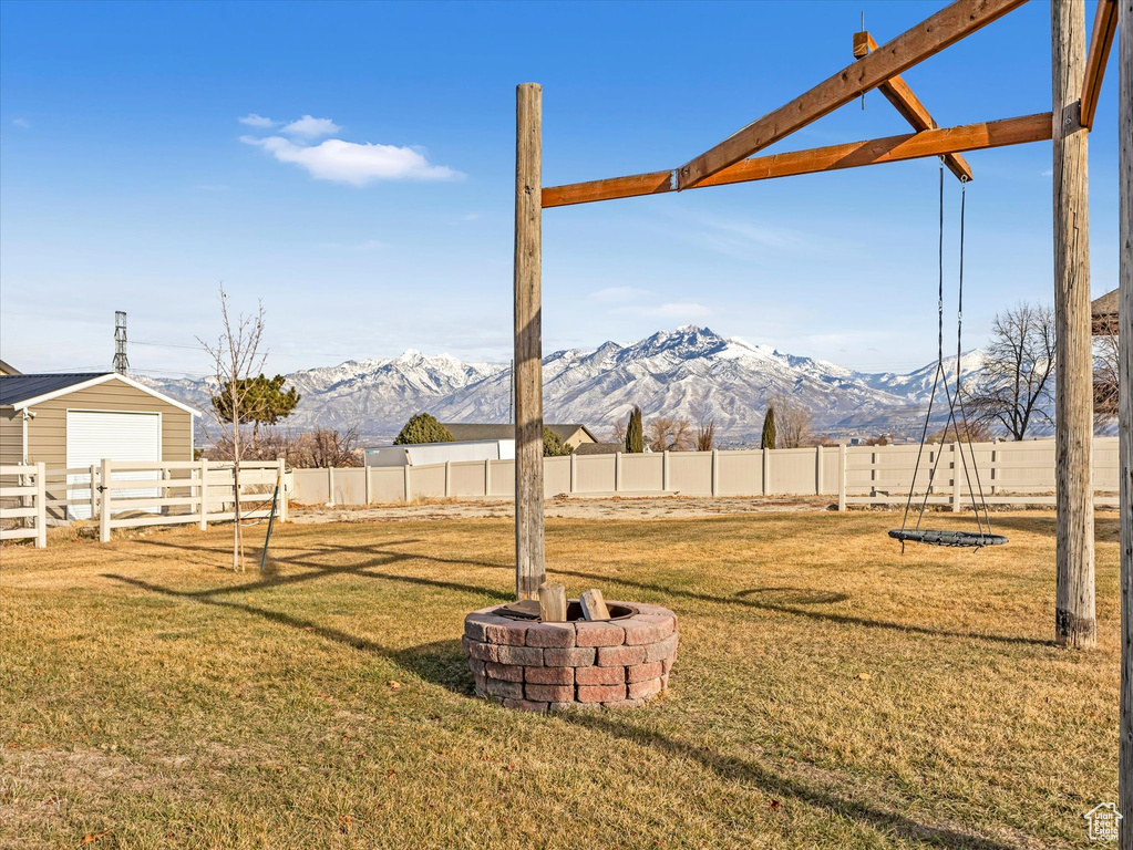 View of yard with an outdoor fire pit and a mountain view
