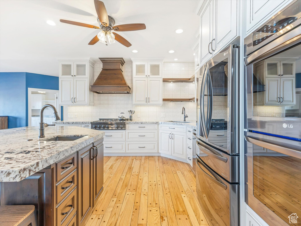 Kitchen featuring white cabinets and custom exhaust hood