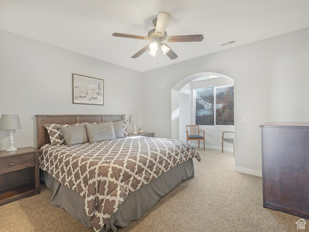 Bedroom with light colored carpet and ceiling fan