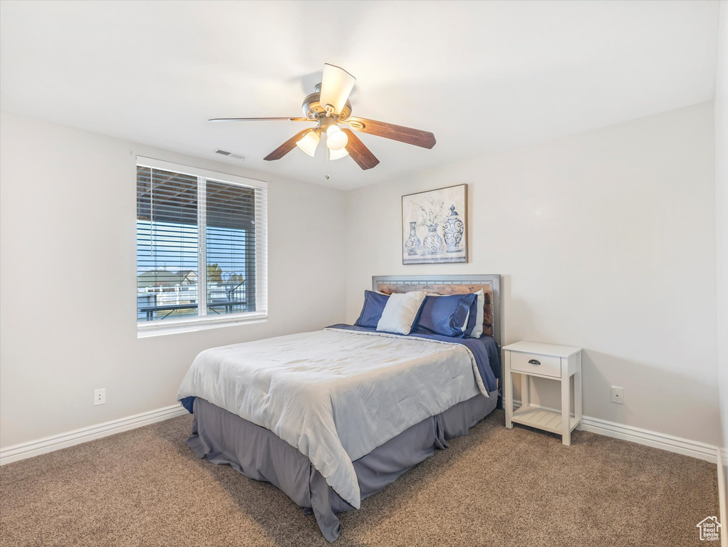 Carpeted bedroom featuring ceiling fan