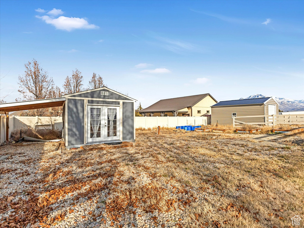 Rear view of property with a storage unit and a mountain view