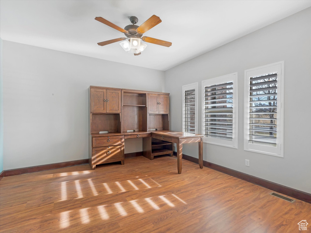 Unfurnished office featuring ceiling fan and hardwood / wood-style flooring