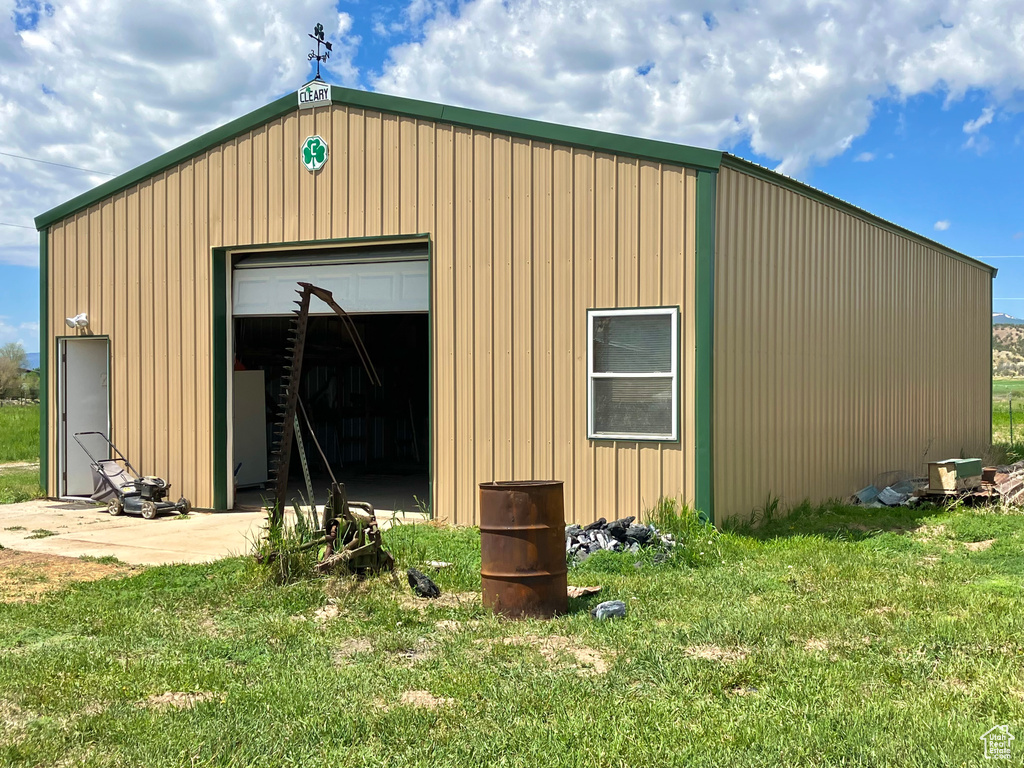 View of outbuilding featuring a yard and a garage