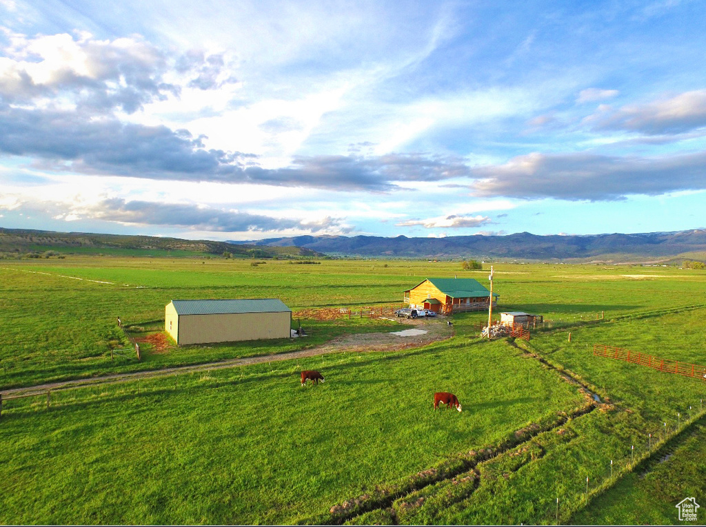 Exterior space featuring a lawn, a rural view, a mountain view, and an outdoor structure