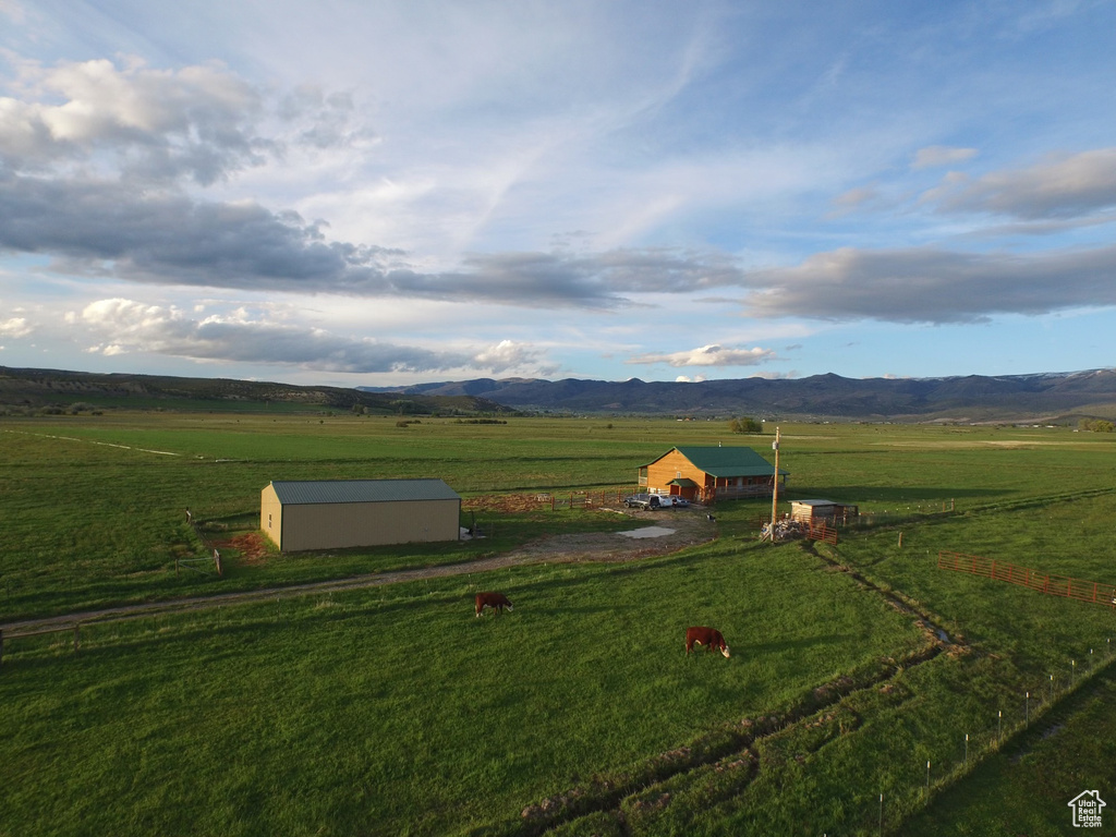 Entry to storm shelter with an outbuilding, a rural view, a mountain view, and a yard