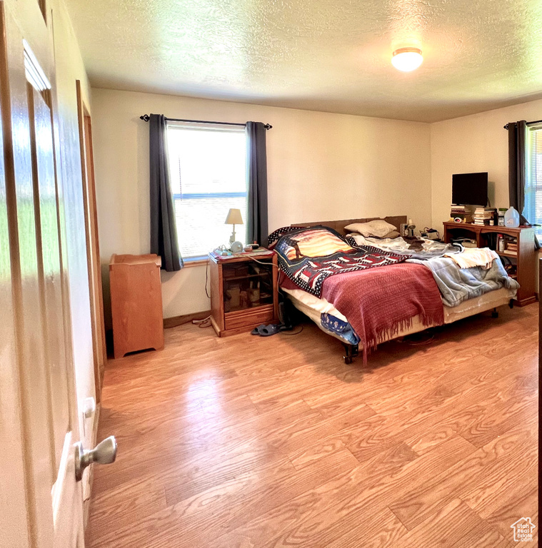 Bedroom featuring a textured ceiling and light hardwood / wood-style flooring