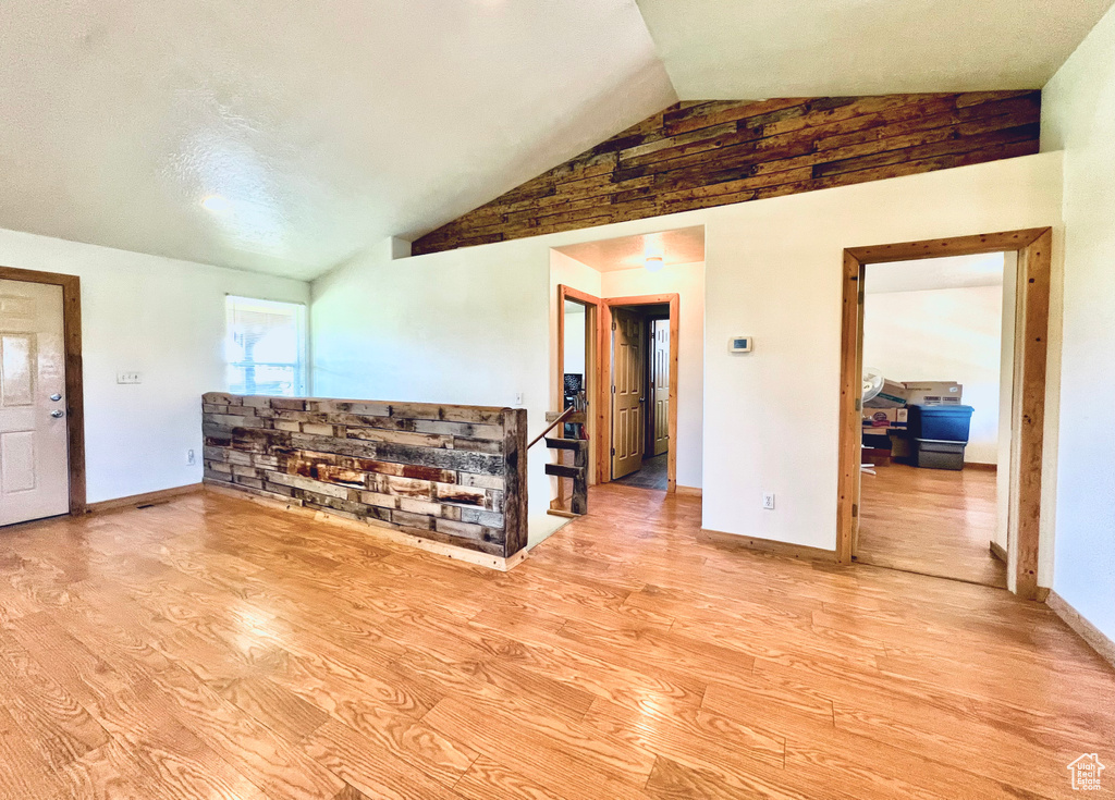 Living room featuring vaulted ceiling and light hardwood / wood-style flooring